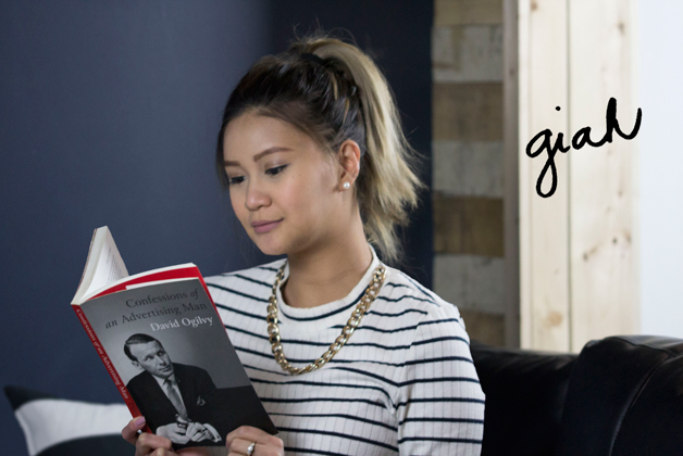 Headshot of Giah Sumalde reading a book with her signature